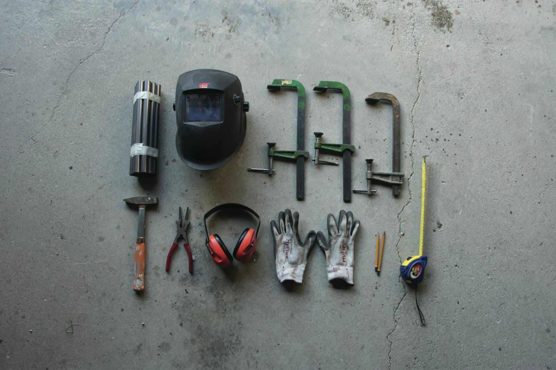 Outils d'artisan disposés sur un sol de chantier